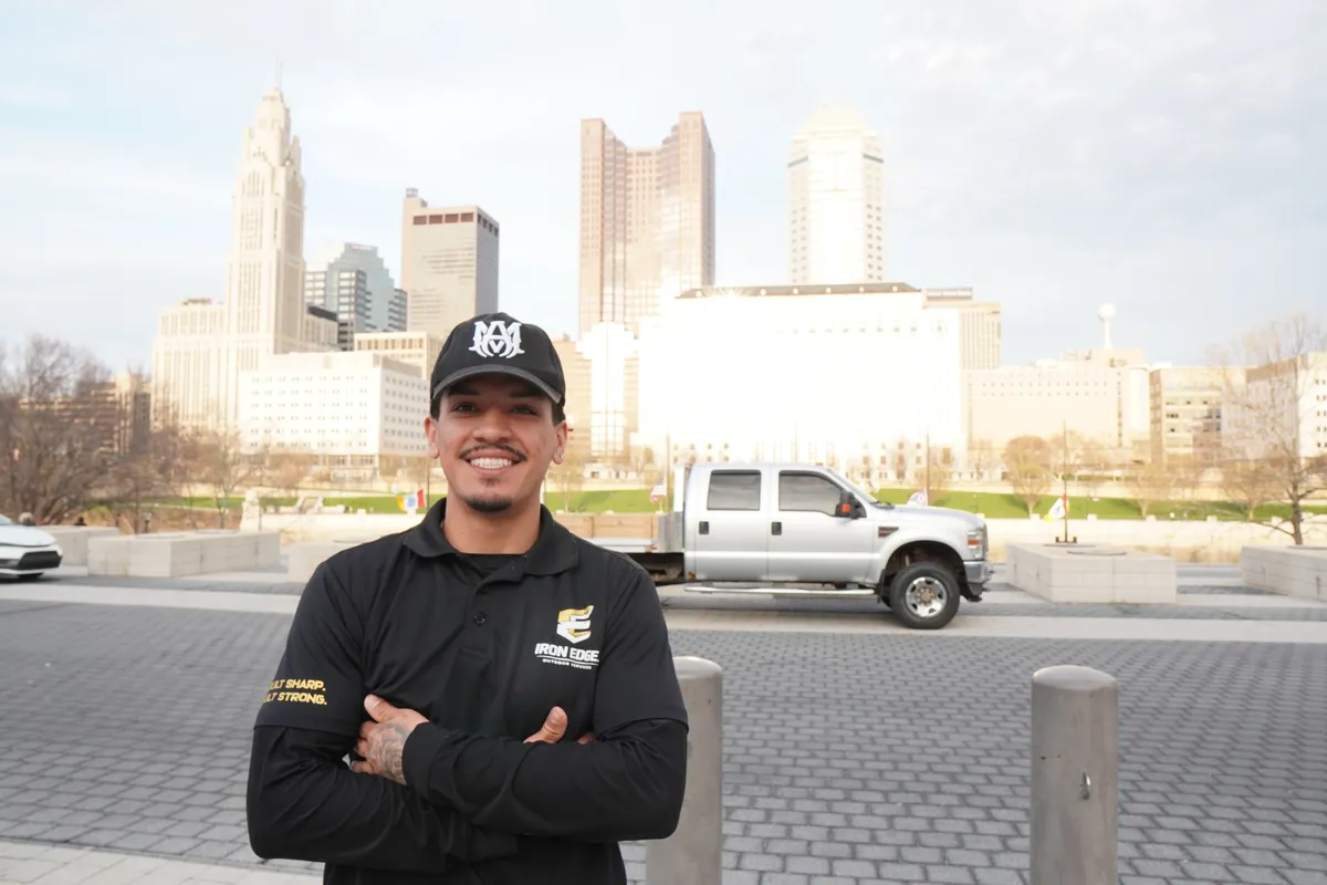Edgar Munoz, owner of Iron Edge Outdoor Services, with Columbus Ohio skyline